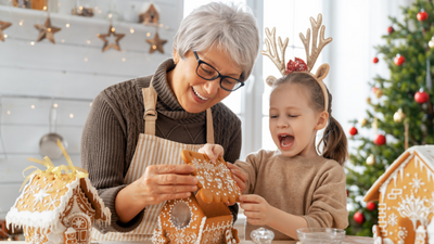 An elderly woman and a child make gingerbread houses