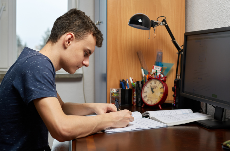 Teenager in bedroom studying