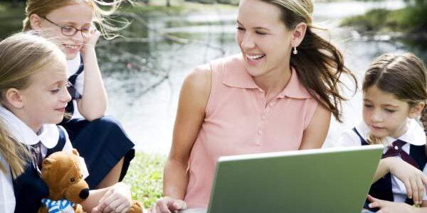 online-safety-training-thumnail-card-600x300-1 Teacher supporting children using a laptop