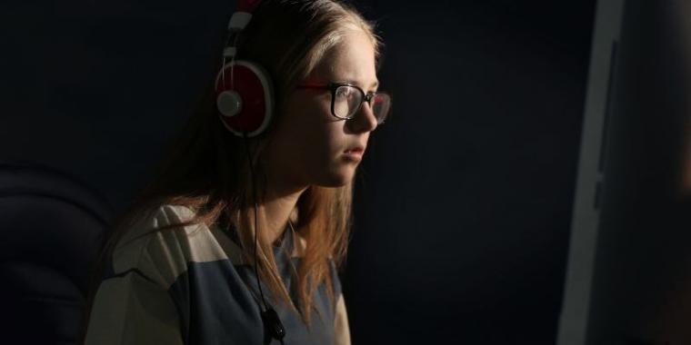 prevent-duty-training-thumbnail-card-760x380-1 Teenage girl in headphones looking at a computer screen in a dark room