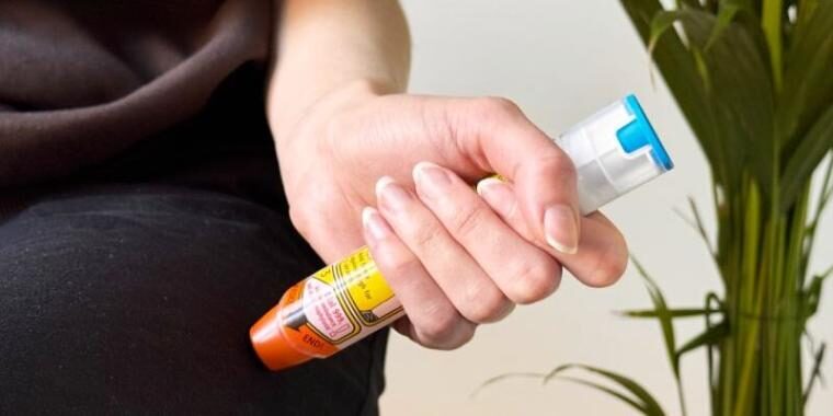 Person holding an adrenaline auto-injector pen
